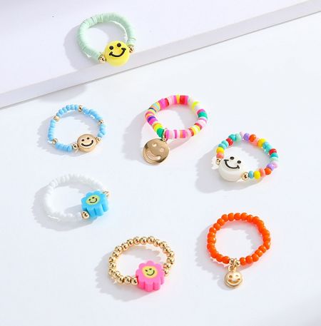 Colorful beaded rings with cheerful smiley face charms.