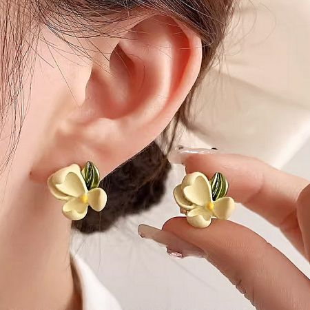 Model wearing the yellow gardenia flower stud earrings, showcasing their size and look.