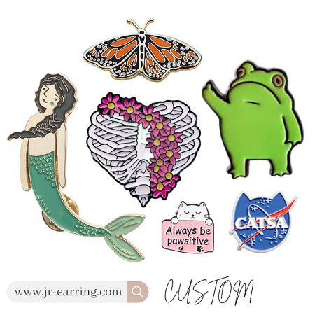 Detailed custom enamel pins including mermaid, butterfly, and frog designs, highlighting intricate craftsmanship.