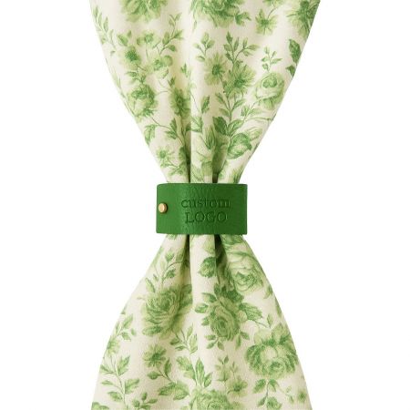 Customizable Leather Napkin Rings for Events and Brands - A neatly folded white napkin held together by a custom brown leather napkin ring, showcasing a sophisticated table setting for events or hotels.