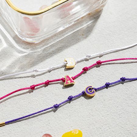 A collection of adjustable friendship bracelets with customizable enamel initial charms.