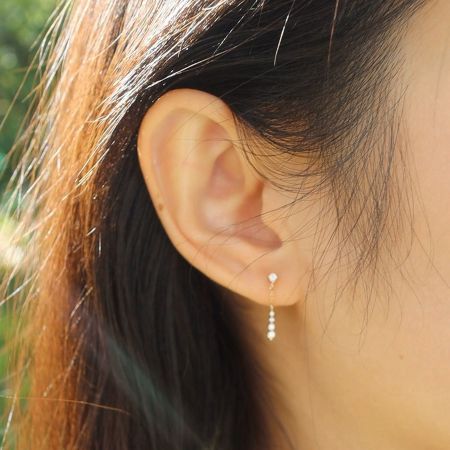 Close-up of a model wearing the gold plated CZ chain drop dangle earrings, perfect for formal events.