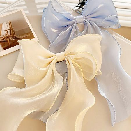 Product shot of the pearlescent ribbon bows in both beige and blue colors.