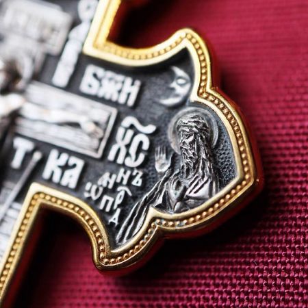 A decorative cross pendant with a gold border and intricate silver metalwork, customizable for religious jewelry.