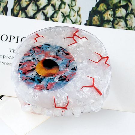 Side view of an Evil Eye claw clip, showing its grip mechanism.