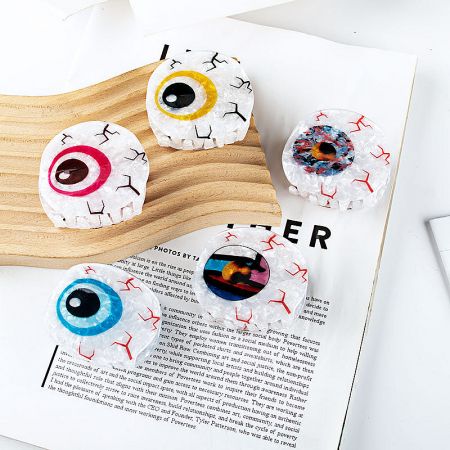 Evil Eye hair clips displayed on a magazine, showing their use as a trendy accessory.