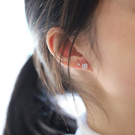 Close-up of a model wearing the ice cube style cubic zirconia stud earrings.