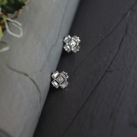 925 Sterling Silver Ice Cube Style Cubic Zirconia Stud Earrings (5 Pairs) - A pair of 925 sterling silver ice cube style stud earrings with cubic zirconia, displayed on a dark wood surface.