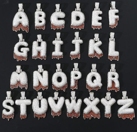 Close-up view of various diamond-encrusted alphabet pendants, highlighting the detailed stone setting.