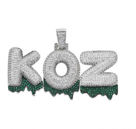 Custom Iced Out Color Name Pendant - A custom iced out name pendant spelling 'KOZ', lavishly set with white and green cubic zirconia stones, showcasing personalized hip-hop jewelry craftsmanship.