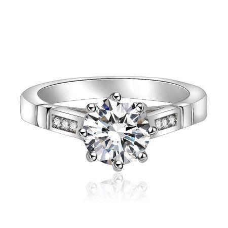 White Round Shoulder Ring - A close-up of the White Round Shoulder Ring, showcasing its central round cubic zirconia stone surrounded by smaller stones on a rhodium-plated brass band.