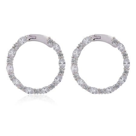 Glitzernde runde Creolenohrringe. - Ein Paar glitzernde runde Creolenohrringe mit Rhodium-Beschichtung, verziert mit funkelnden weißen Zirkonia-Steinen, präsentiert auf einem sauberen weißen Hintergrund.