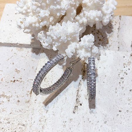 A pair of the large silver hoop earrings with cubic zirconia, showing their impressive size and shine.