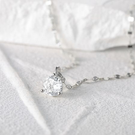 Angled shot of the sparkling single stone pendant on the silver chain.