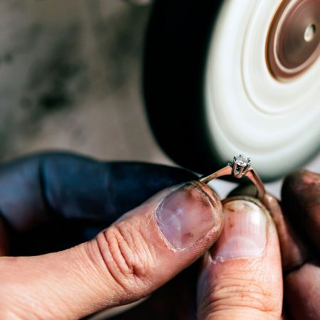 A skilled jeweler meticulously polishing a custom-designed stainless steel ring during the OEM process.