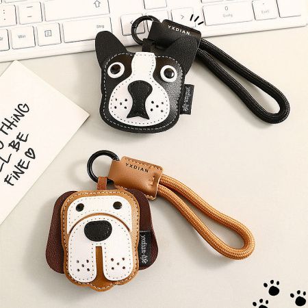 Side-by-side view of the black and brown dog-face leather keychains.