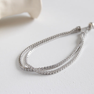 Detailed shot of the luxurious double-strand silver bracelet, emphasizing the brilliance of the clear stones.