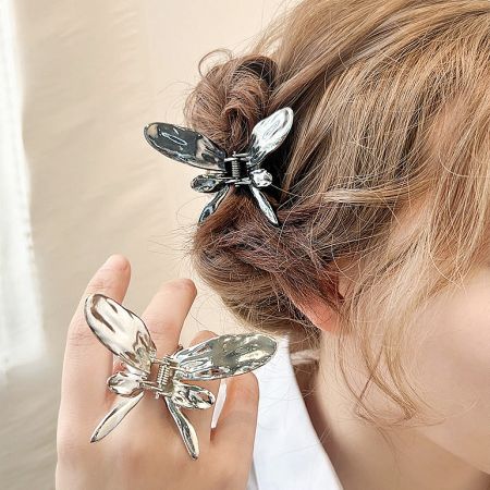 A model showcasing the metal butterfly hair clip styled in her elegant updo.
