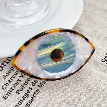 Detailed close-up of the blue Evil Eye hair claw clip, highlighting the intricate design and acetate material.