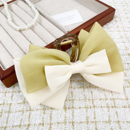 A lifestyle shot of the fabric bow hair clips with other fashion accessories.