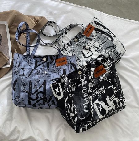 A collection of three hand-printed tote bags showcasing different graffiti designs and color variations.