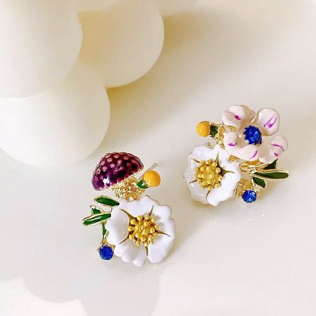 Two pairs of colorful enamel flower earrings.