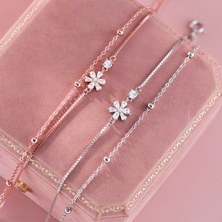 Women's 925 Sterling Silver Flower Zircon Dainty Double Layer Bracelet Set of 5 - A set of three elegant 925 sterling silver bracelets with sparkling cubic zirconia flower charms, displayed in a pink jewelry box.