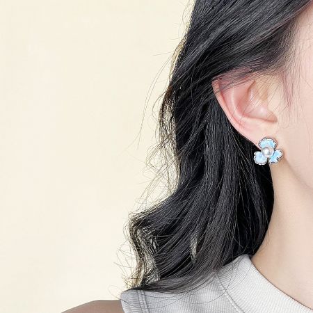Close-up view of the iris flower earring highlighting the central pearl detail.