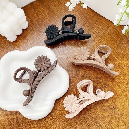 Wholesale Daisy Flower Hair Claw Clips (5 pcs) - A set of four daisy flower hair claw clips in assorted colors: pink, brown, walnut, and black, displayed on a white background.
