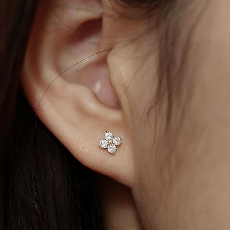 925 Silver Tiny Lucky Four-Leaf Zircon Flower Stud Earrings (5 pairs) - A close-up of a woman wearing a 925 sterling silver four-leaf clover stud earring, featuring sparkling zircon stones.
