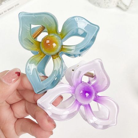Two flower-shaped hair clips in different colors.