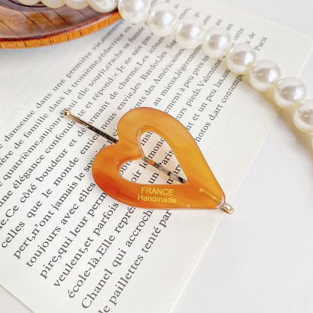 A single, elegant tortoiseshell patterned heart-shaped hair clip labeled 'FRANCE Handmade'.