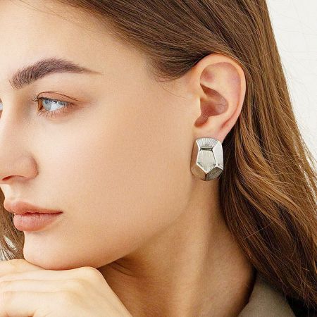 Model showcasing the silver version of the geometric striped pentagon stud earring.