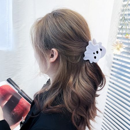 A model wearing the white ghost hair clip, demonstrating how it adds a festive touch to a hairstyle.