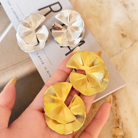 A pair of gold and a pair of silver ginkgo leaf earrings.