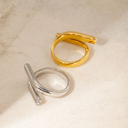 Close-up of the gold and silver geometric rings on a marble surface.