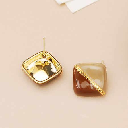 Detailed view of the two-tone enamel square earrings, highlighting the brass setting and stone-like finish.