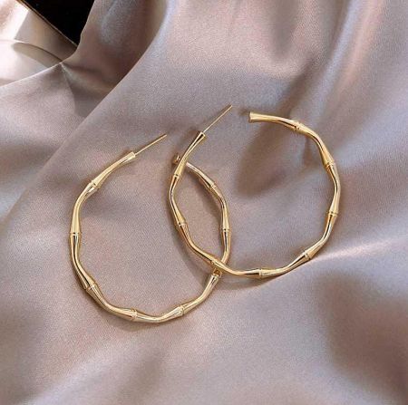 Side view of the gold hoop earrings with a distinct bamboo design.