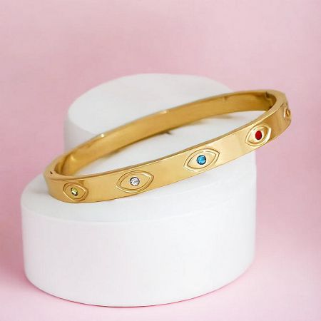 A stylish gold bangle bracelet showcasing its colorful gemstone embellishments.