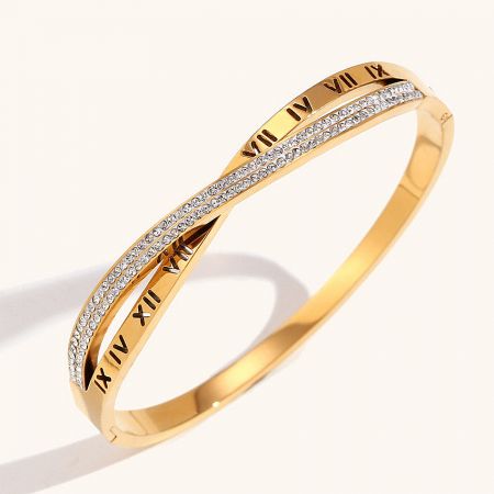 Close-up view of the gold bangle bracelet highlighting the detailed Roman numerals and sparkling cubic zirconia cross.