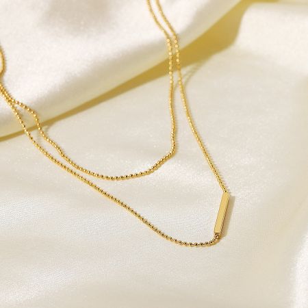 Angled view of the stainless steel gold bar pendant necklace.