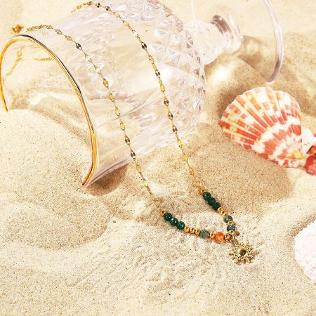 The complete jewelry set, including necklace and bracelet, styled in a beach setting.