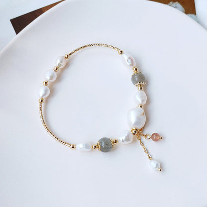 The bracelet set includes a piece with a delicate tassel charm, adding a touch of bohemian flair.