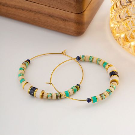 A pair of stainless steel Lazurite beaded hoop earrings shown against a neutral background.
