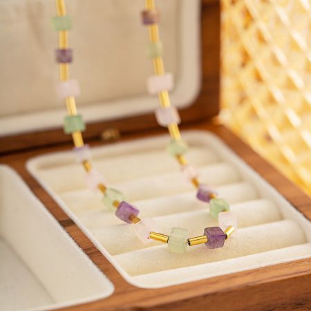 The stainless steel beaded necklace elegantly displayed in a wooden jewelry box.