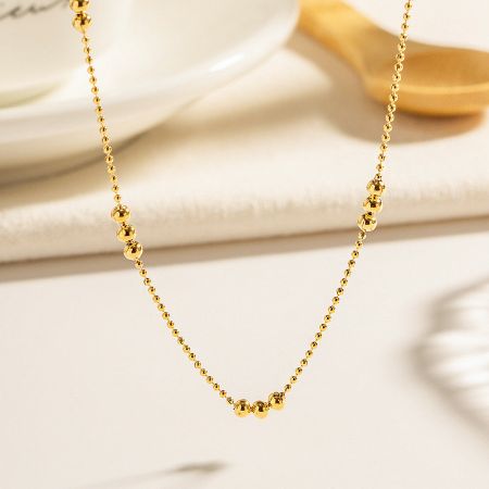 Product shot of the stainless steel three-beaded chain necklace.