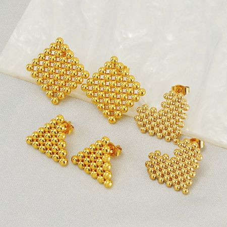 A collection of gold earrings with a unique beaded design, shown on a neutral background.