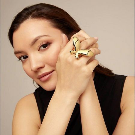 Side profile of a model wearing the unique gold bird-shaped ring.