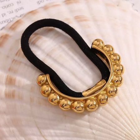 Women's Ponytail Hair Ties - 18K Gold Plated Stainless Steel Hair Cuff (Set of 5) - A stylish 18K gold plated stainless steel hair cuff with a black elastic tie, featuring a decorative gold bead detail, displayed on a seashell.