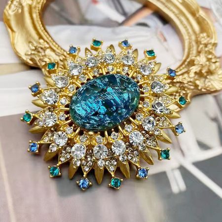 Gold-Plated Crystal Sun Vintage Brooch Pin Set (5 pcs) - A luxurious gold-plated vintage sun brooch pin with a large central blue gemstone surrounded by sparkling clear and blue crystals.
